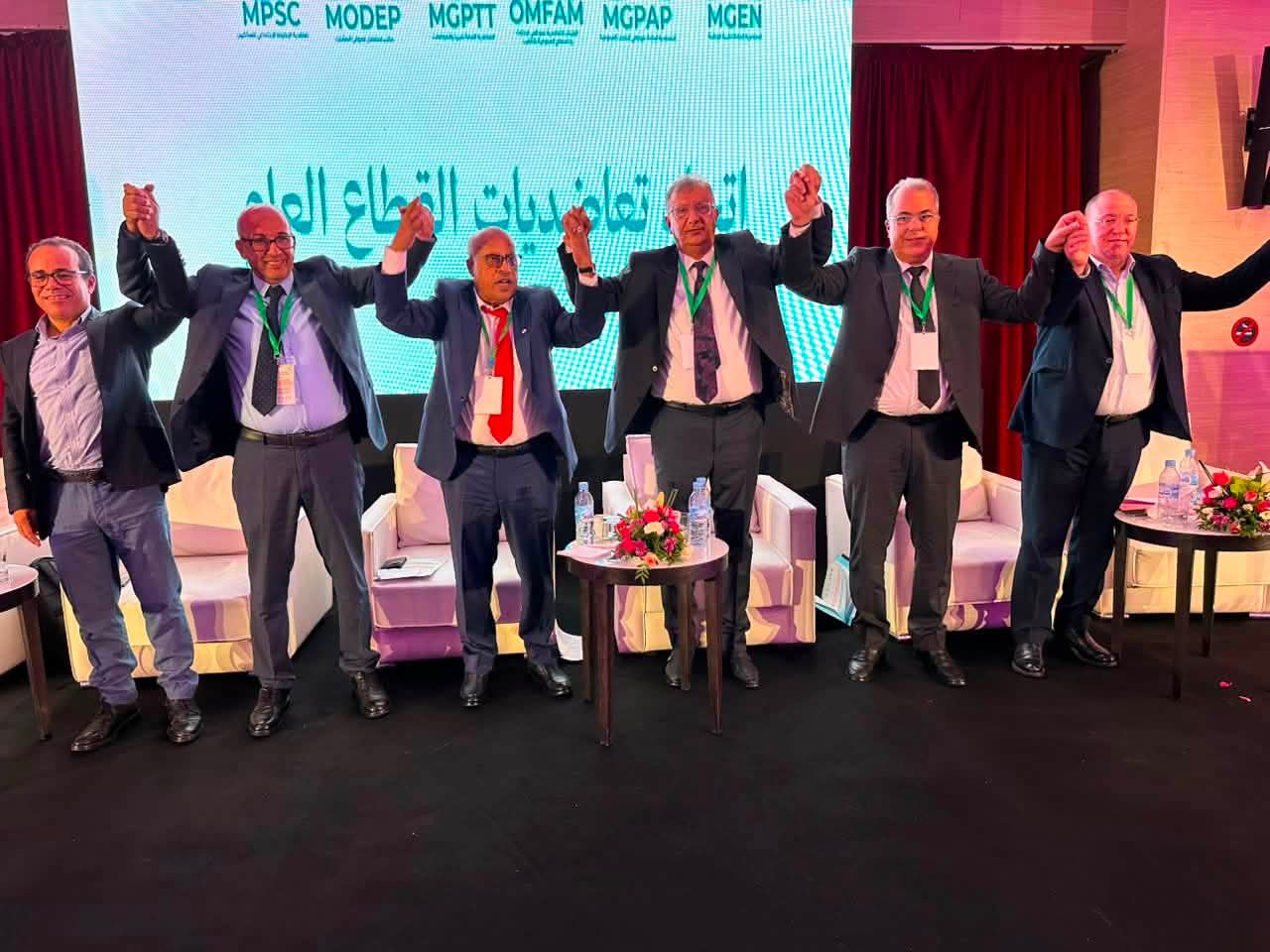 خمسة مسؤولين يحتفلون على خشبة مسرح بعد انتخاب إطار تعاضدي جديد بطنجة