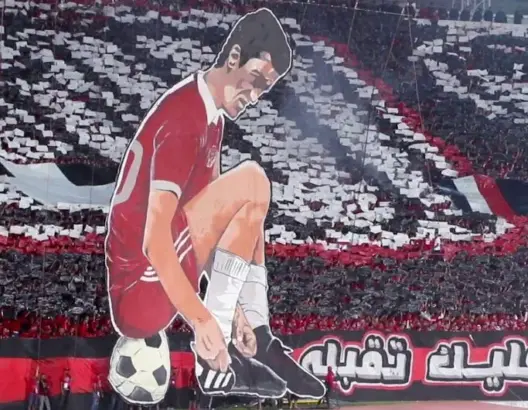 جماهير الوداد تستحضر تاريخ الديربي بتيفو خيالي للاعب بيتشو (فيديو)