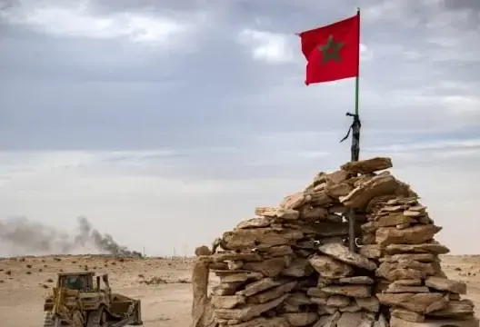 جرافة تمر على قمة تل يسكنها جنود مغاربة على طريق بين المغرب