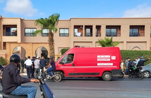 الصورة توثق لحظة استنفار أمني وصحي عقب حادثة السير المميتة التي شهدتها طريق أوريكة قرب المزار بمراكش صباح اليوم الإثنين فاتح شتنبر. ويظهر في المشهد تدخل عناصر الأمن الوطني والوقاية المدنية، إلى جانب سيارة إسعاف حمراء متوقفة أمام مبنى، فيما تجمع بعض المواطنين لمتابعة التطورات. ويأتي ذلك في سياق الحادث المؤلم الذي أودى بحياة شاب كان على متن دراجة نارية من نوع "سي 50"، بعد اصطدامه بسيارة خفيفة، في واقعة خلفت حزنا عميقا لدى أسرته وأهالي المنطقة.