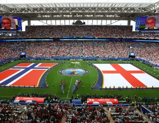 ملعب كرة قدم مزدحم بأعلام النرويج وإنجلترا وشعار أزرق ذهبي في مونديال 2026