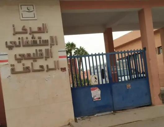 مدخل المركز الاستشفائي الاقليمي بالراحمنة وبوابة معدنية زرقاء مغلقة