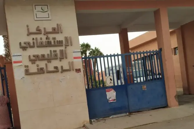 مدخل المركز الاستشفائي الاقليمي بالراحمنة وبوابة معدنية زرقاء مغلقة