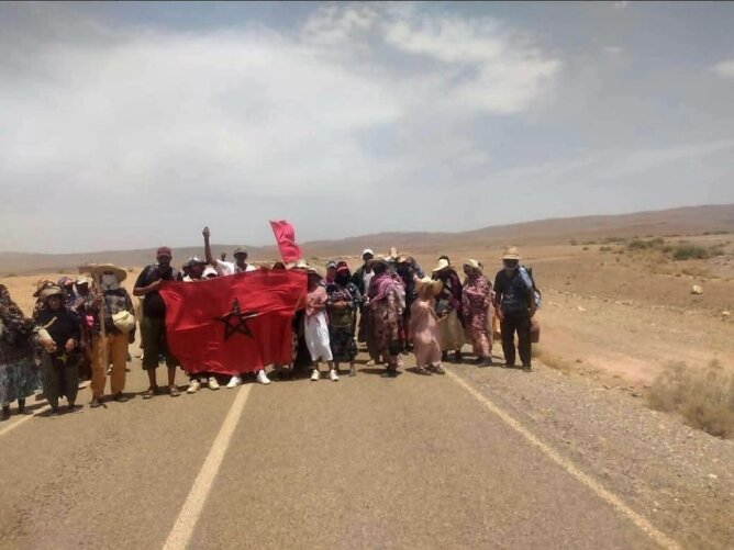 مجموعة تحمل علم المغرب في مسيرة احتجاجية بصحراء الرشيدية
