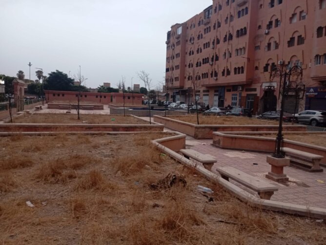 حديقة عامة مهملة تحت الإنشاء قرب مبانٍ سكنية في مراكش