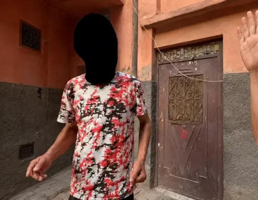 شخصان في زقاق ضيق بمراكش قرب باب خشبي قديم خلال خلاف