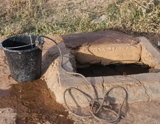 بئر مائي تقليدي بحبل ودلو في منطقة جافة تعبير عن مخاطر المطفيات