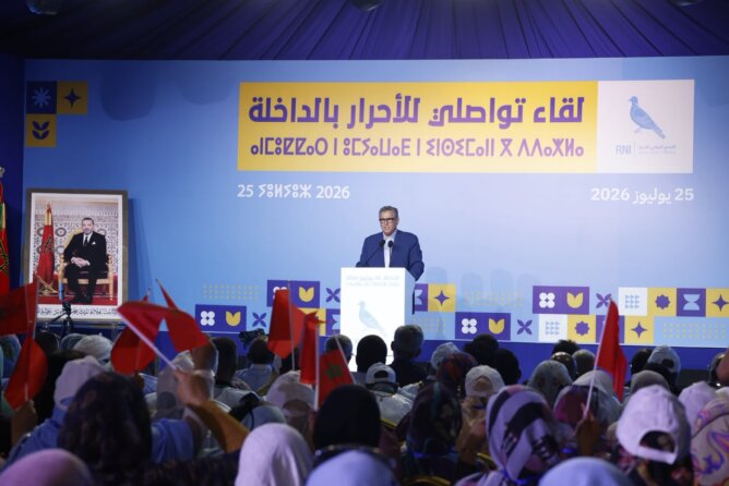 اجتماع حزبي بالأعلام الحمراء في قاعة مؤتمرات كبيرة تحت شعار المركز الدولي