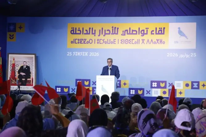 اجتماع حزبي بالأعلام الحمراء في قاعة مؤتمرات كبيرة تحت شعار المركز الدولي