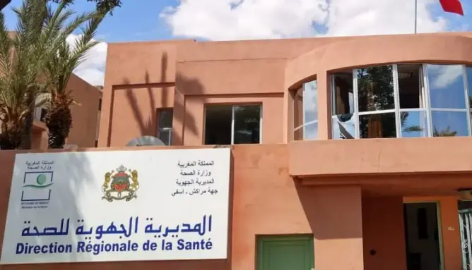 مبنى المديرية الجهوية للصحة باللافتة الرسمية وعلم أحمر وأشجار نخيل