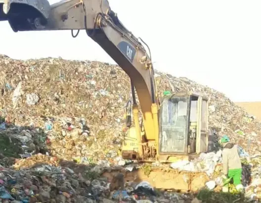 آلة حفر تعمل في مكب نفايات بوادي زم وسط تراكم المخلفات البيئية