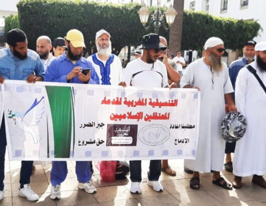 مجموعة رجال يحملون لافتة تضامن عربي لإغاثة زلزال سوريا وتركيا في ساحة عامة