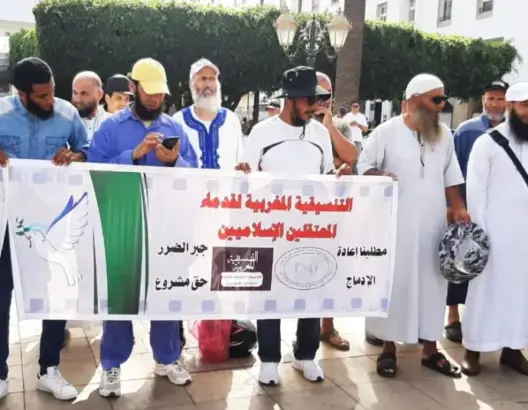 مجموعة رجال يحملون لافتة تضامن عربي لإغاثة زلزال سوريا وتركيا في ساحة عامة