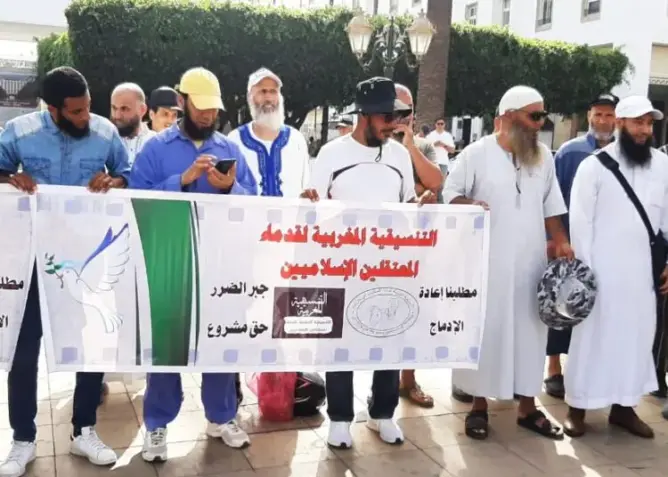 مجموعة رجال يحملون لافتة تضامن عربي لإغاثة زلزال سوريا وتركيا في ساحة عامة
