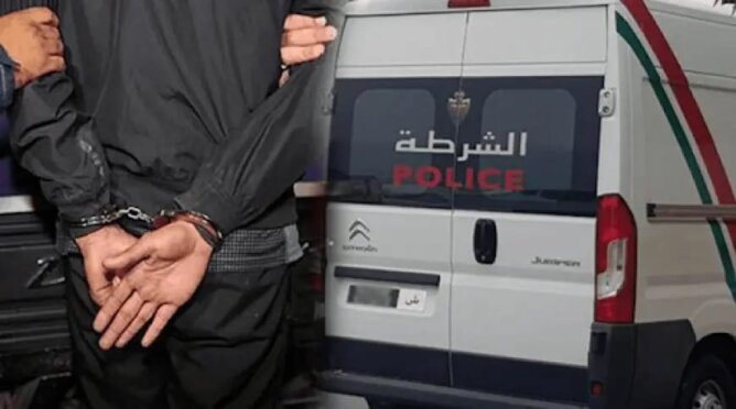 شخص مقيد أمام سيارة شرطة تحمل شعار الشرطة في عملية أمنية بمراكش