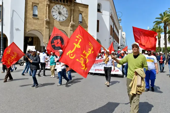 أعضاء ومناصرون للنهج الديمقراطي العمالي خلال مسيرة ترفع أعلام الحزب بالمغرب